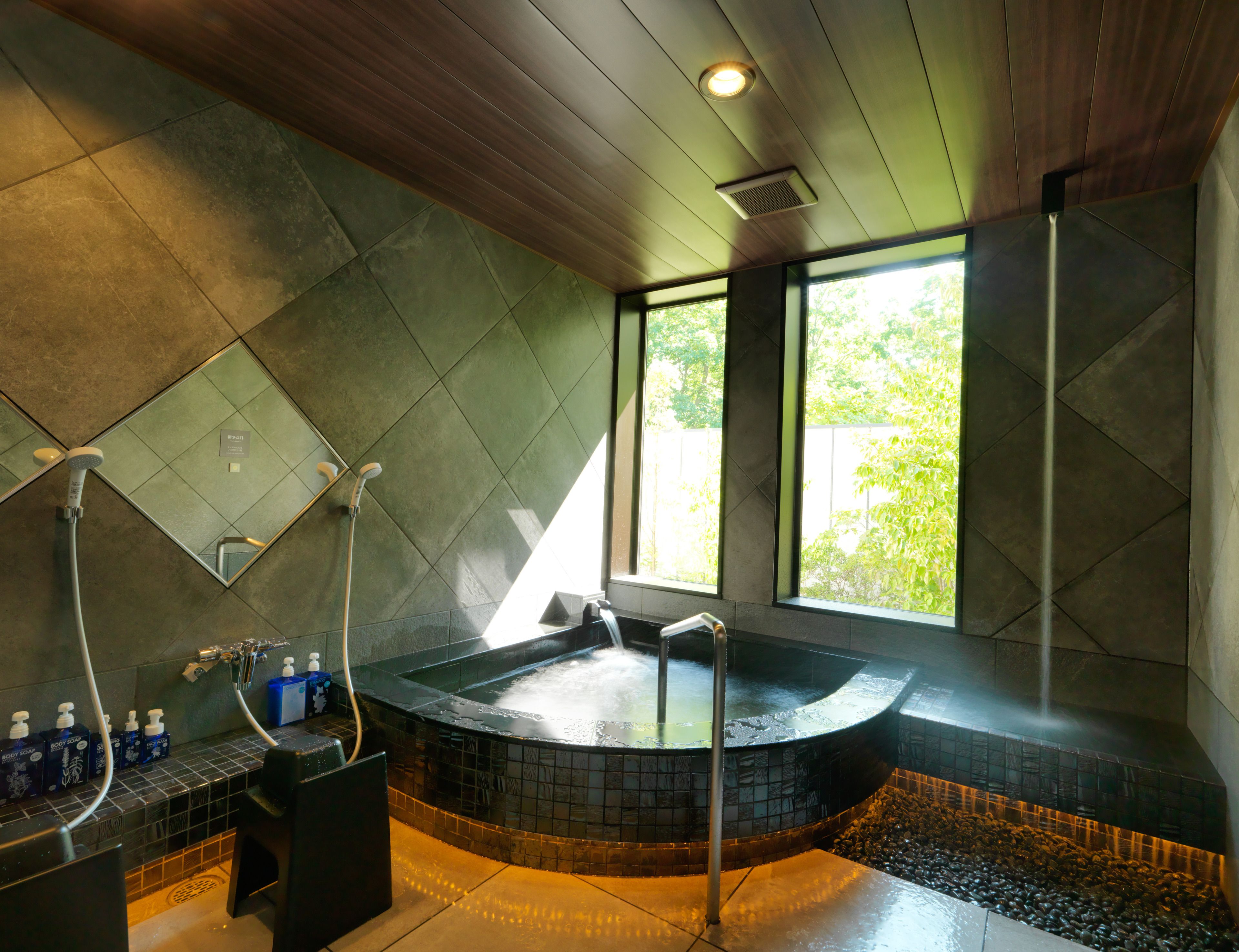 Un baño moderno con una bañera independiente, ducha y ventana que proporciona luz natural.