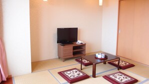 A small room with a television on a wooden stand, a small table, and tatami mats on the floor. - Hotel Castle Village Miyakojima (Miyakojima)