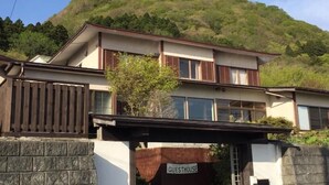 A two-story building with a sign reading "GUESTHOUSE" at the entrance. - Hakodateyama Guest House - Hostel (Hakodate)
