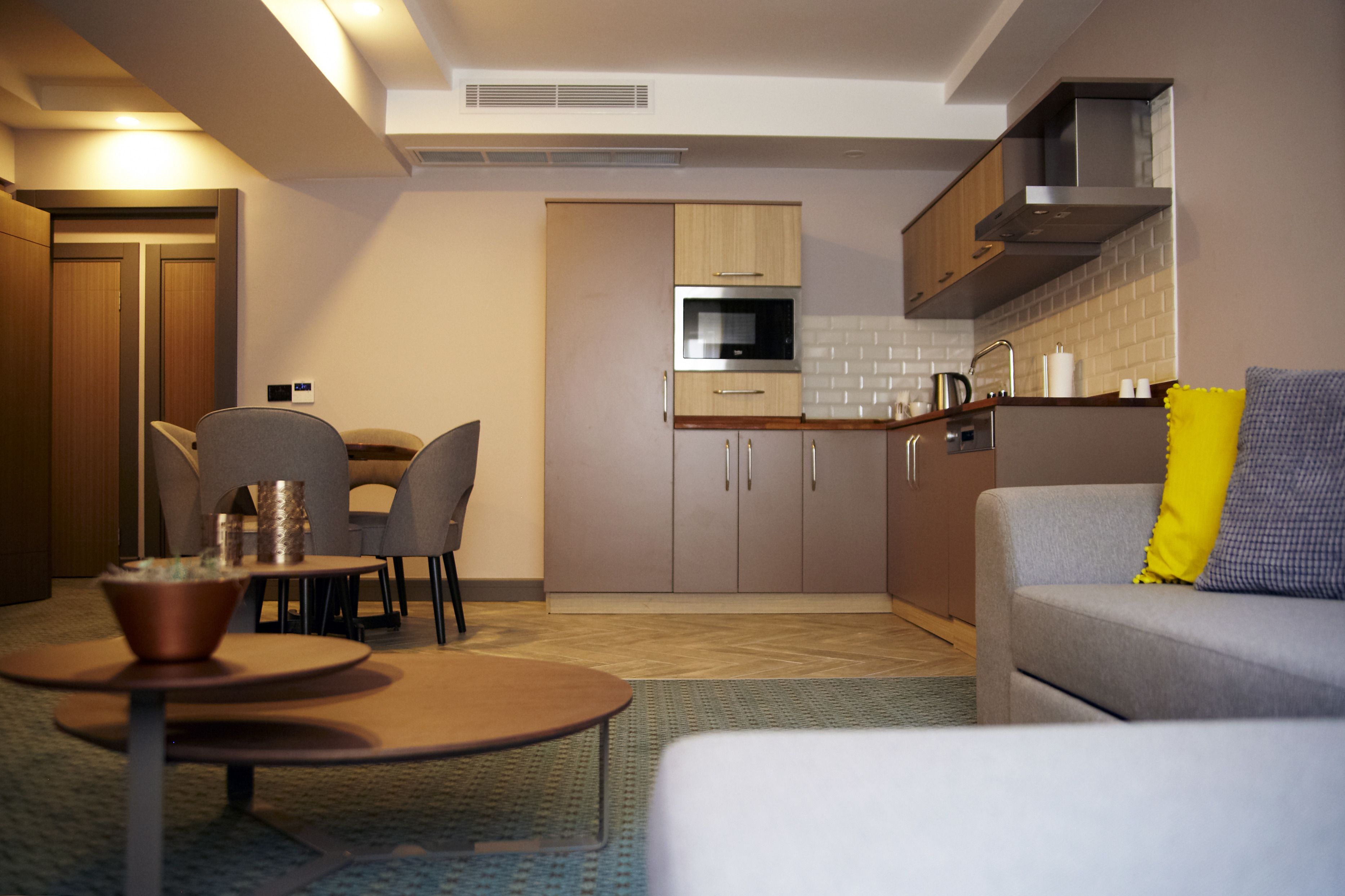 A compact living space with a kitchenette, dining area, and seating.