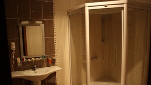 A bathroom with a glass-enclosed shower, a sink, and a mirror. - Qafqaz Sahil Resort Hotel (Lankaran)