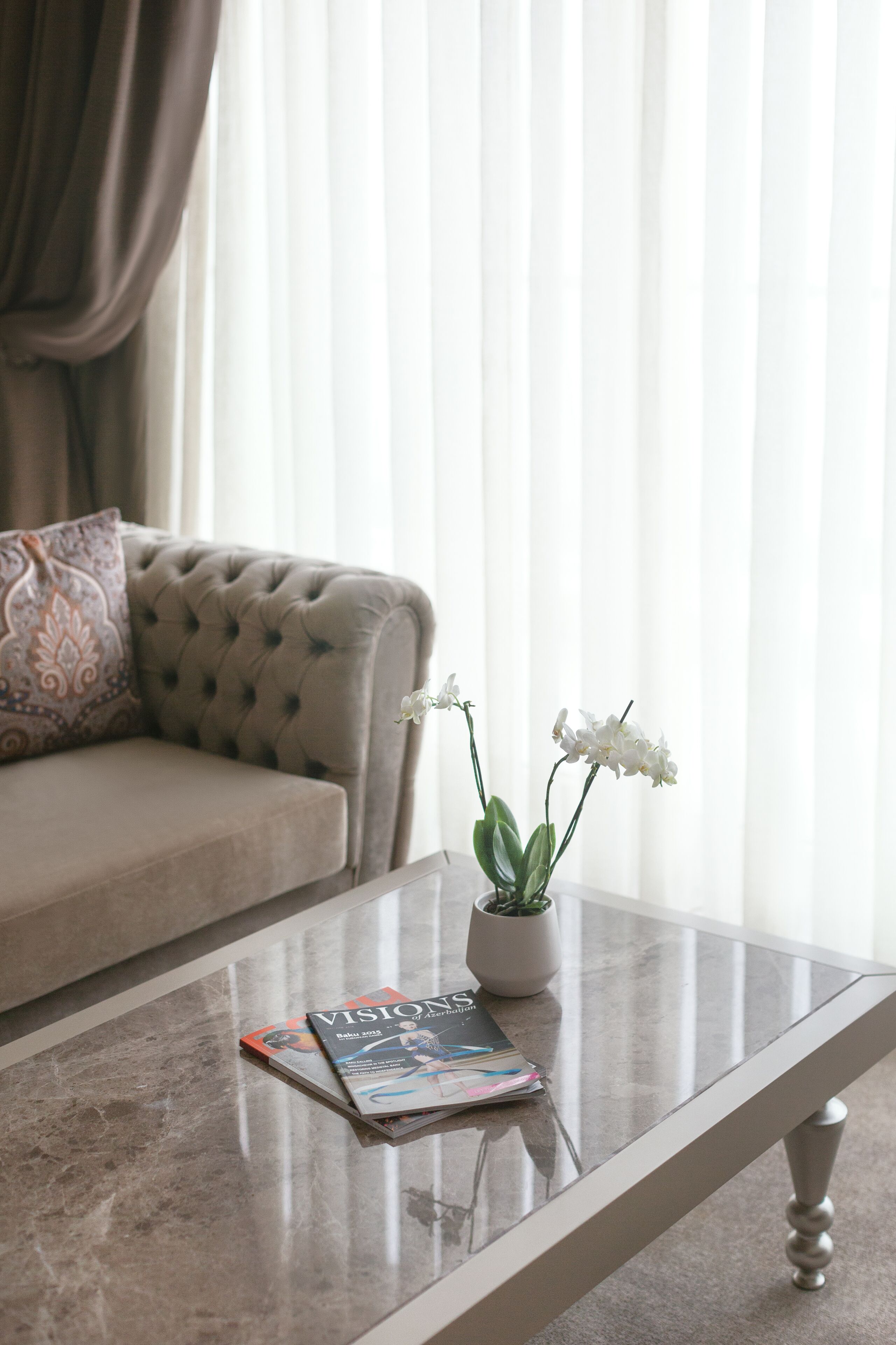 A living room with a sofa, a coffee table, and a magazine.