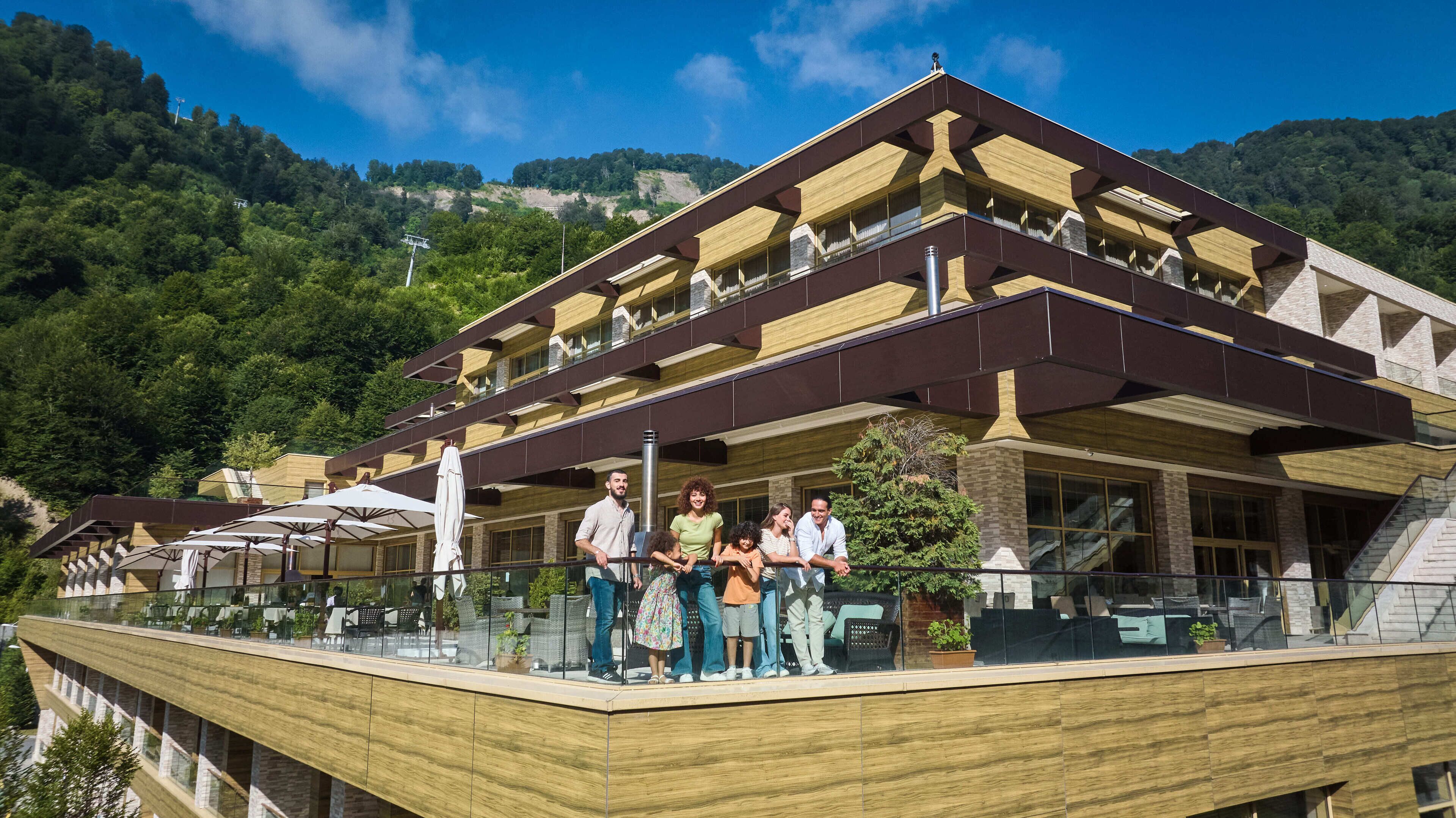 A modern building with a balcony overlooking a mountainous area.