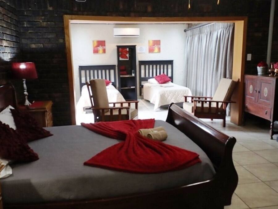 Una habitación de hotel con una cama grande, dos sillas, un escritorio y un armario.