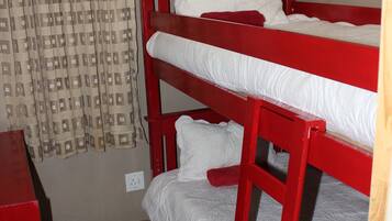 A bunk bed room with a curtain and a red desk.