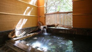 Un área de aguas termales con construcciones de madera y una cerca de madera.