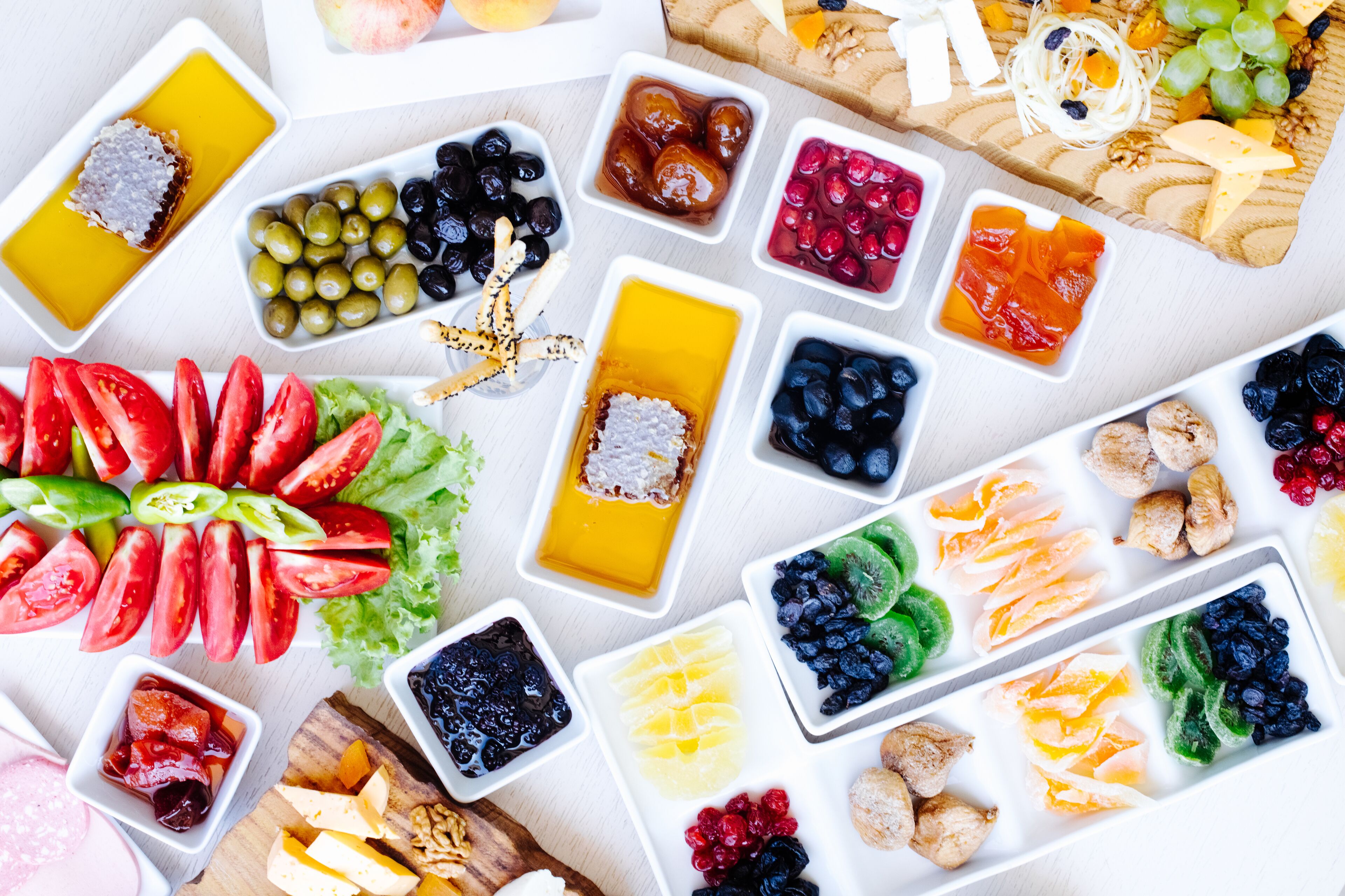 A variety of food items arranged on a table, including fruits, vegetables, and cheese.