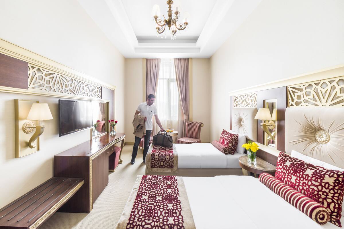 Una habitación de hotel con una cama grande, un sofá, un escritorio y un televisor.