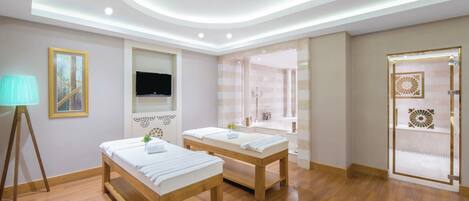 A modern room with two wooden beds, a TV, a lamp, and a bathroom with a shower and toilet.