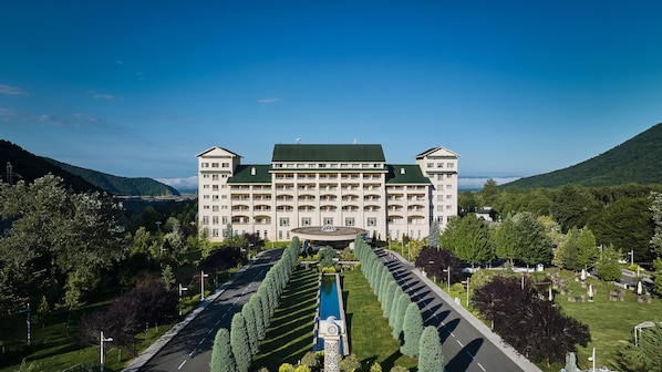 A large, multi-story hotel with a symmetrical facade, central courtyard, and a fountain.