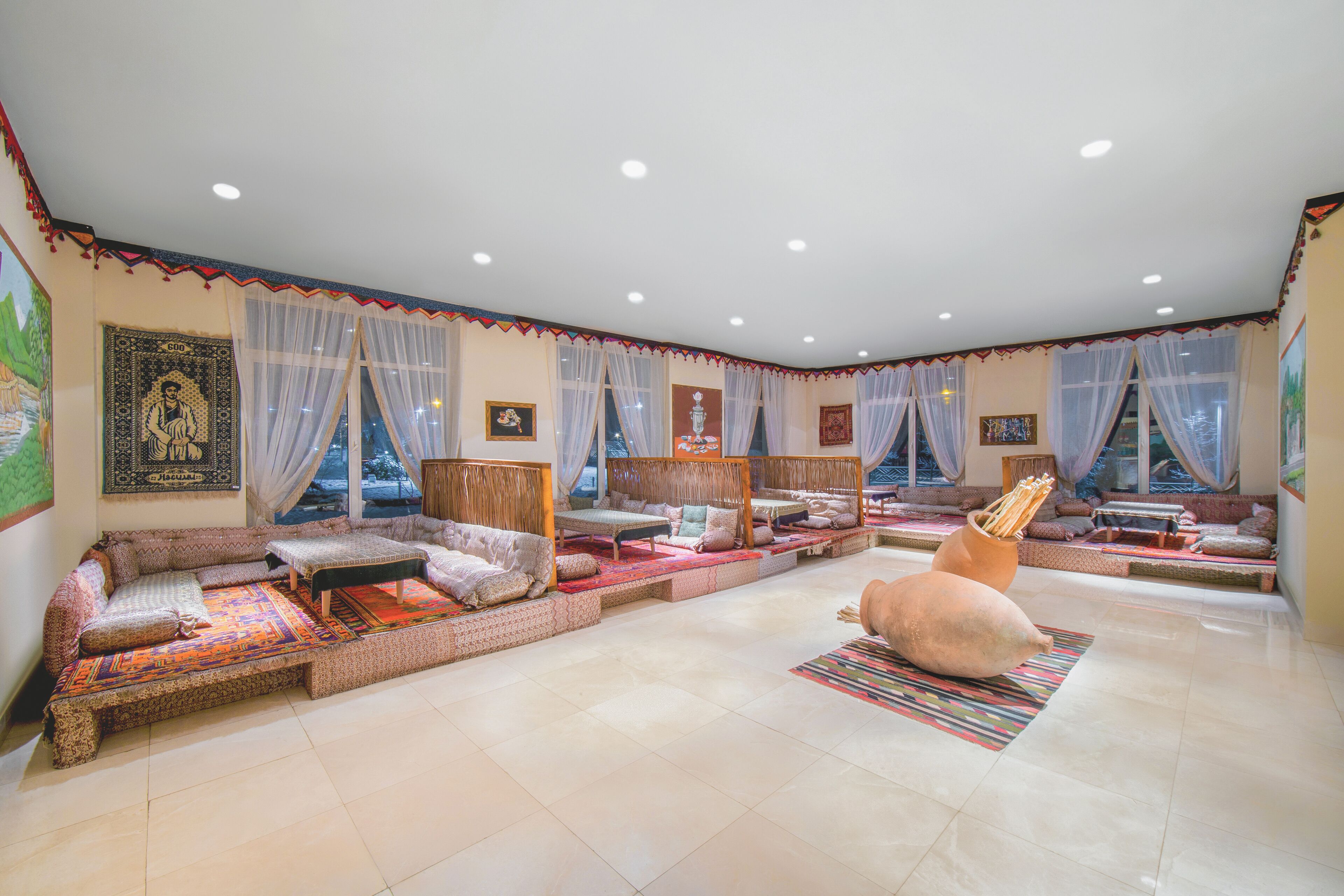 A spacious living area with multiple seating options, including sofas and a large rug.