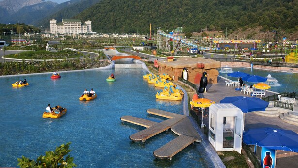 A water park with inflatable rafts, a wooden dock, and a small building with a red sign. - Qafqaz Riverside Resort Hotel (Gabala)