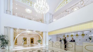 A grand lobby with a chandelier, reception desk, and a double-height ceiling. - Qafqaz Riverside Resort Hotel (Gabala)