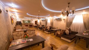 A spacious living area with multiple seating options, including sofas and armchairs, arranged around a central coffee table. -  Qebele Yeddı Gozel Hotel (Gabala)