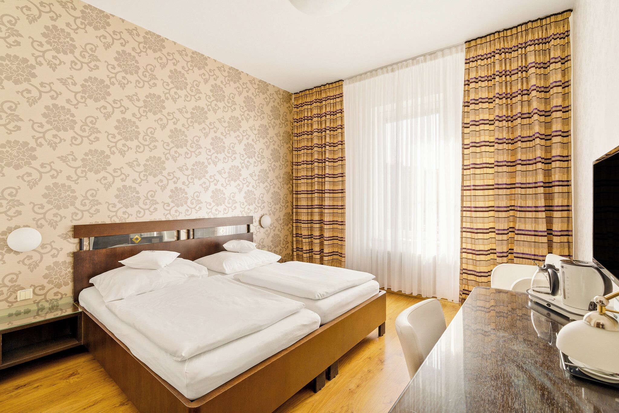 Une chambre d’hôtel avec un lit, un bureau et une chaise.