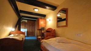 Un dormitorio con dos camas de madera, un escritorio y una silla.