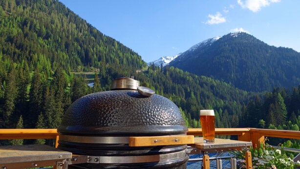 A barbecue grill with a beer on a wooden table, overlooking a forested mountain. - Alkira (Sankt Anton am Arlberg)