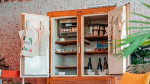 Un refrigerador antiguo con estantes abiertos que contienen diversos alimentos y botellas.