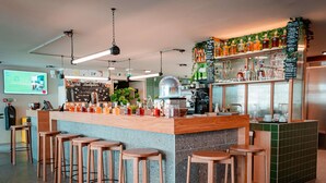 Zona de bar con taburetes, una barra y un panel con la carta.