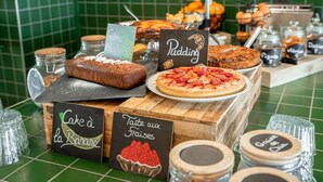 Mostrador de panadería con diversas opciones de productos horneados y etiquetas que indican diferentes tipos de pasteles y dulces.