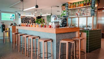 A bar area with stools, a counter, and a menu board.