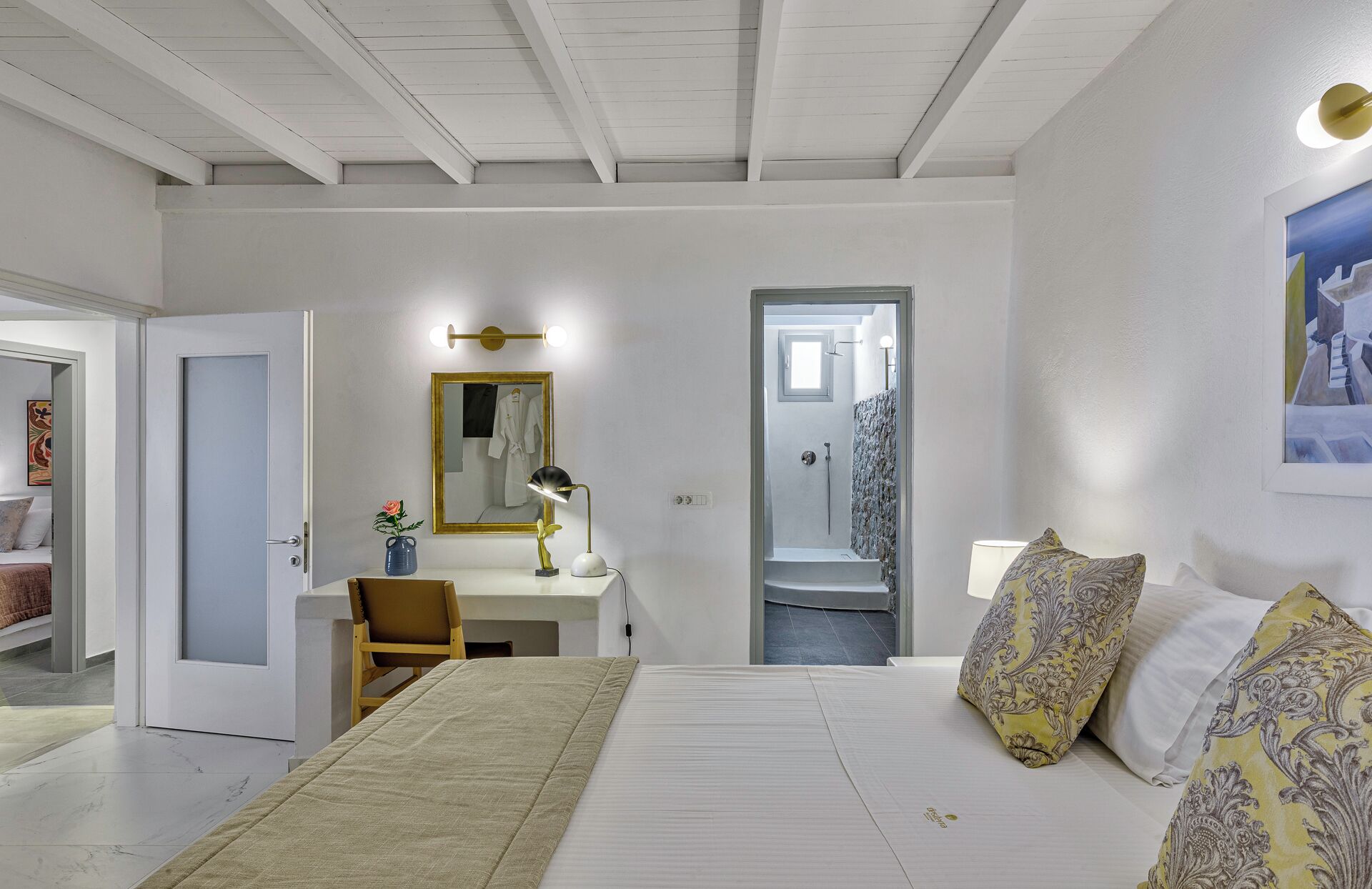 A modern bedroom with a bed, bedside table, mirror, and a shower area.