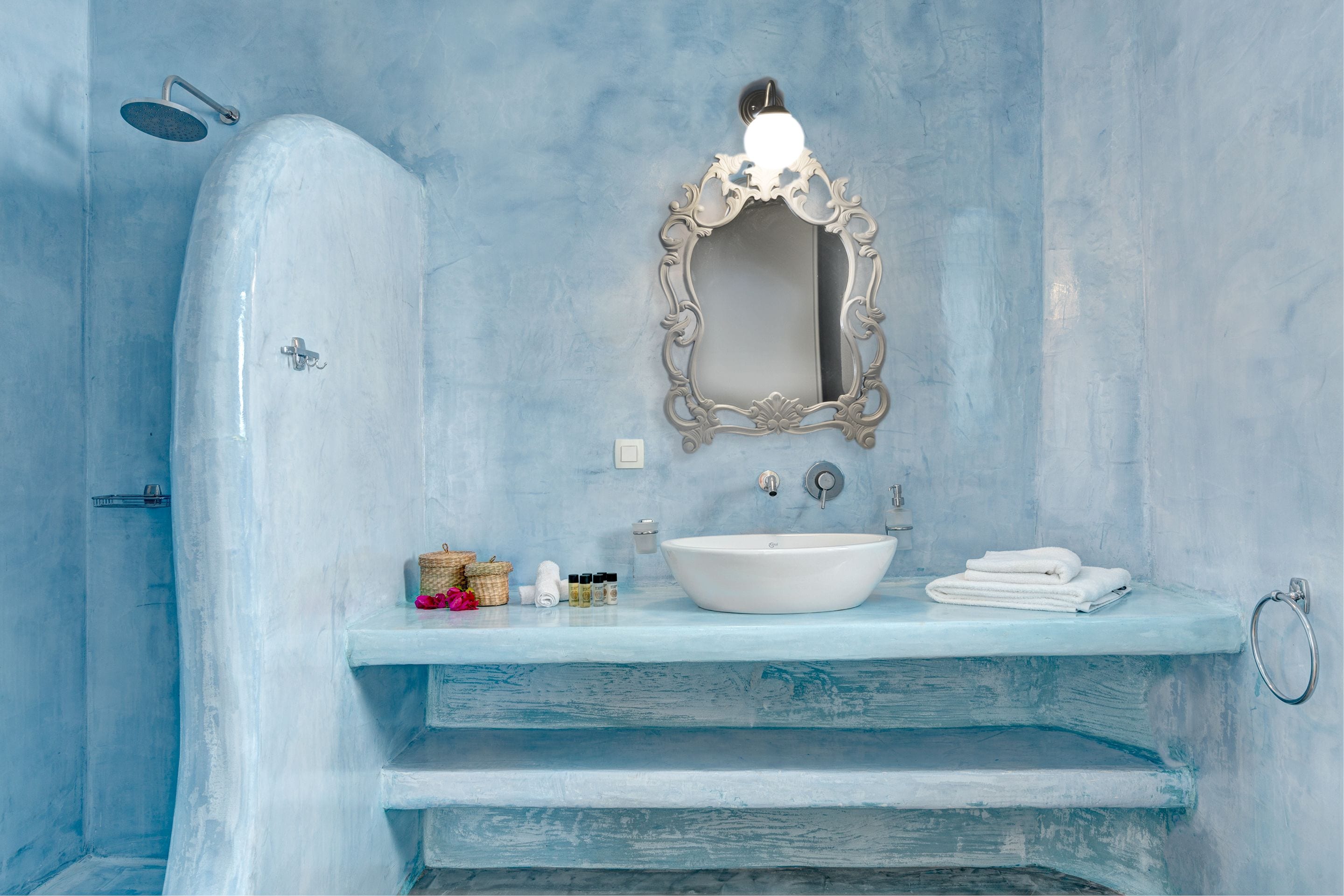 A bathroom with a white bathtub, a sink with a mirror, and a towel rack.