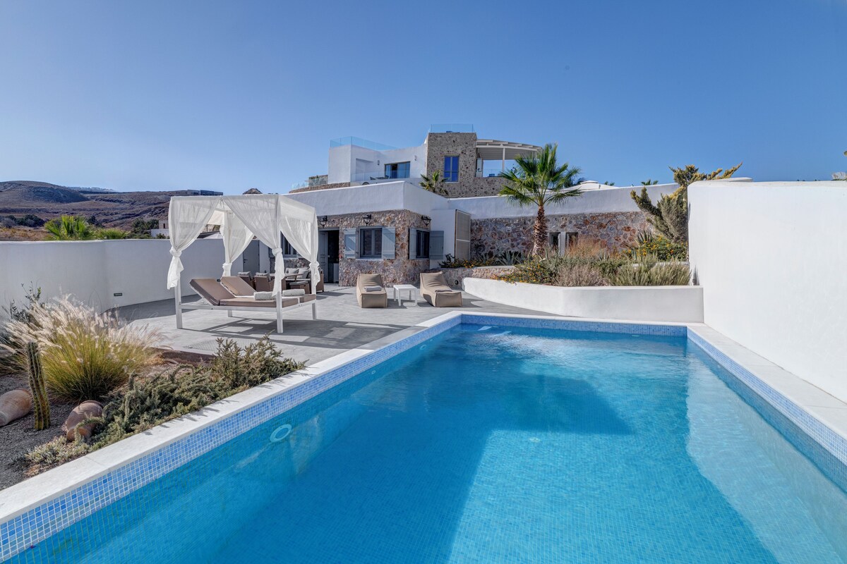 Un área de piscina moderna con piscina azul cristalina, sillones de descanso y un toldo blanco.