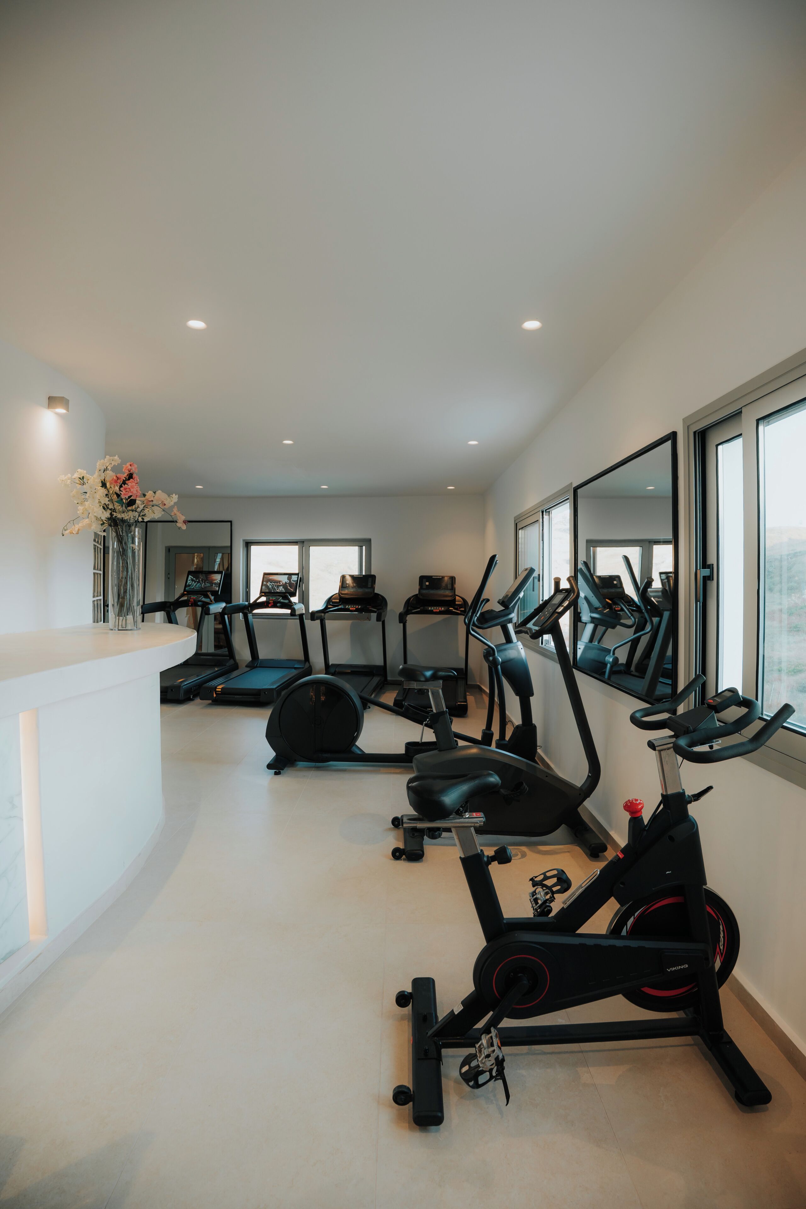 A home gym with exercise equipment, a large mirror, and a window.
