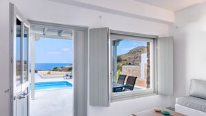 Una habitación moderna con vista a una piscina y al mar.