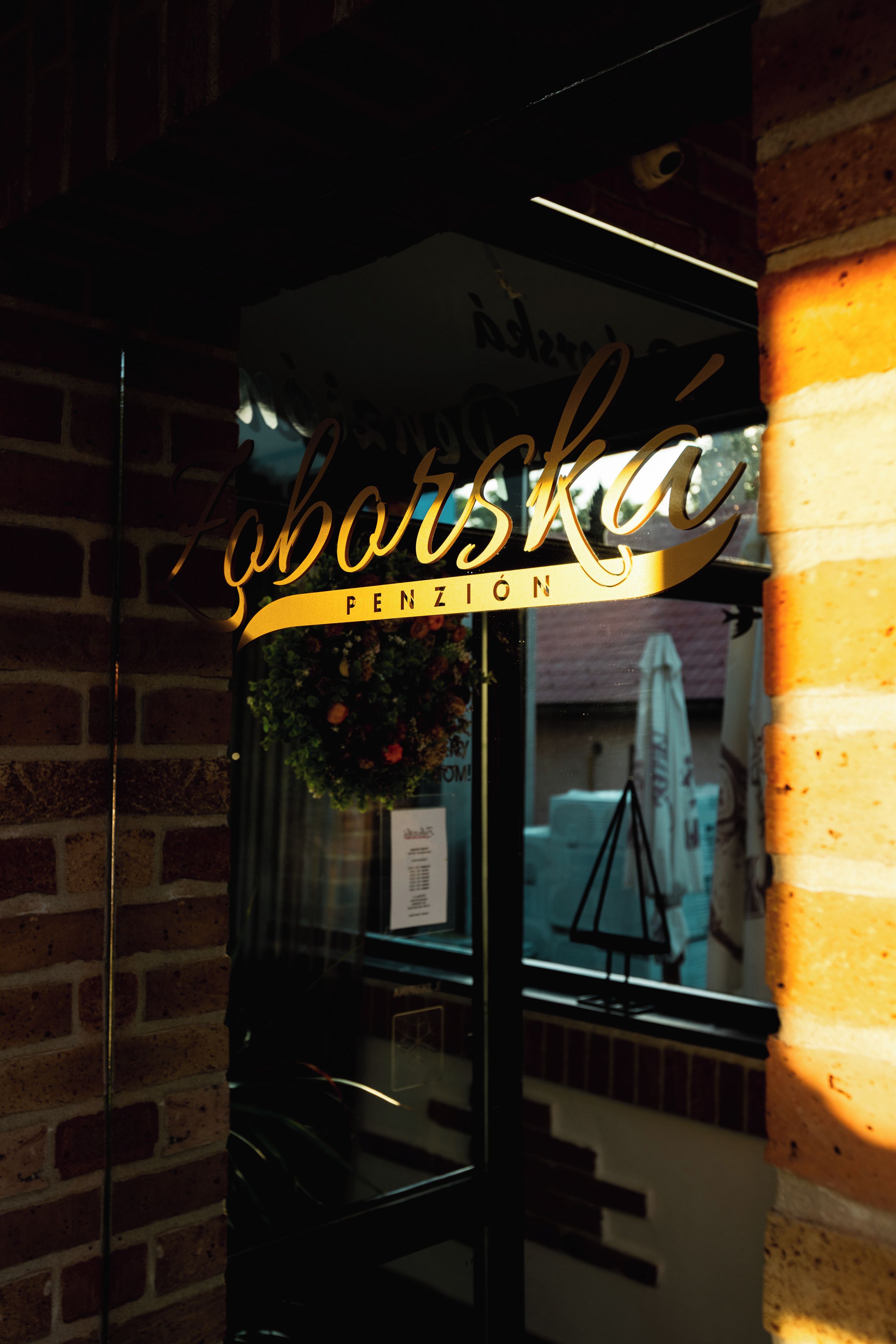 A storefront with a glass door and a sign that reads 'Saborska PENZION'.
