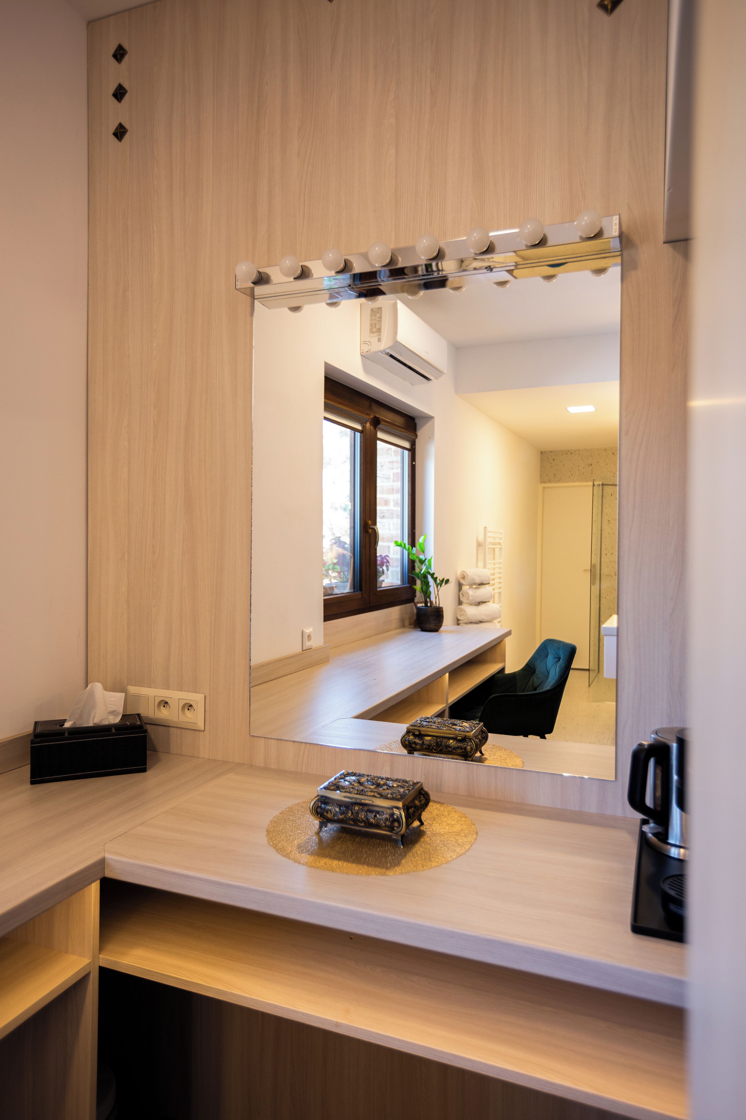Un baño moderno con tocador, espejo y una pequeña planta.