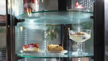 A dessert display case with various desserts on multiple shelves.