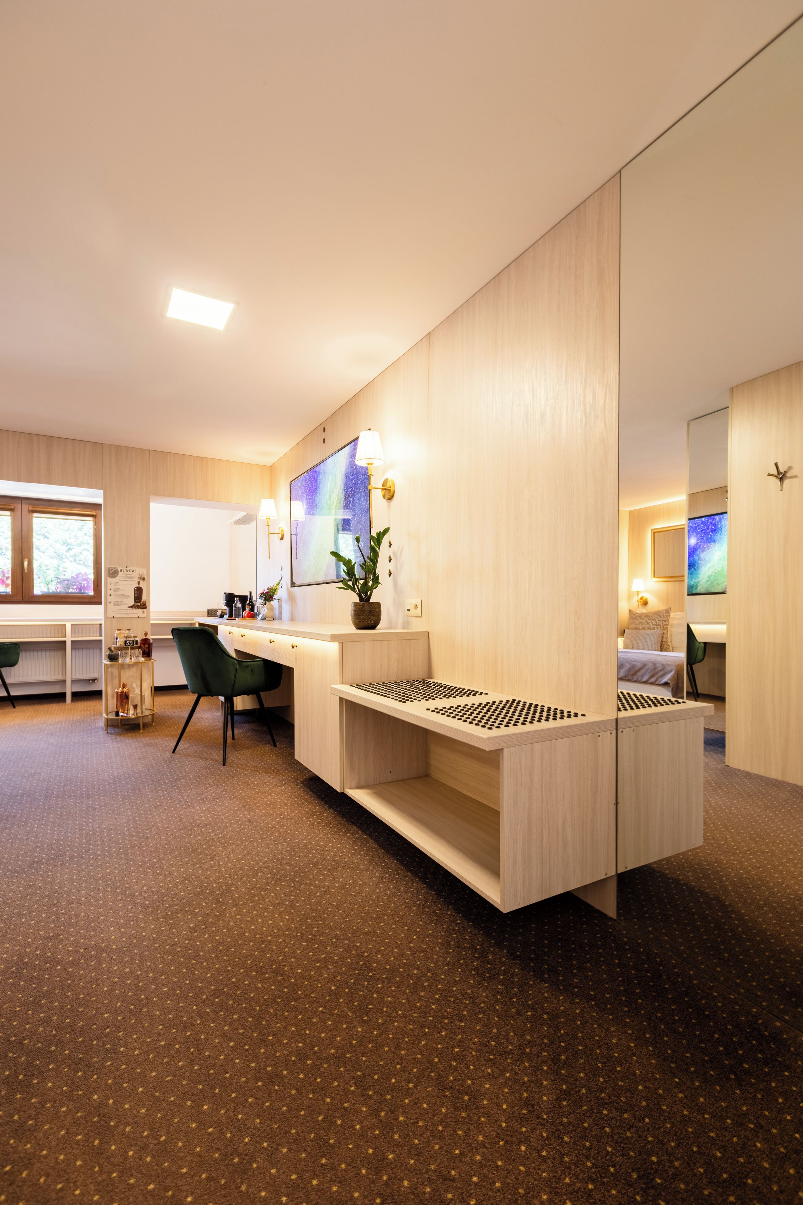 Habitación de hotel moderna con escritorio, silla y cama con vistas al cielo nocturno.