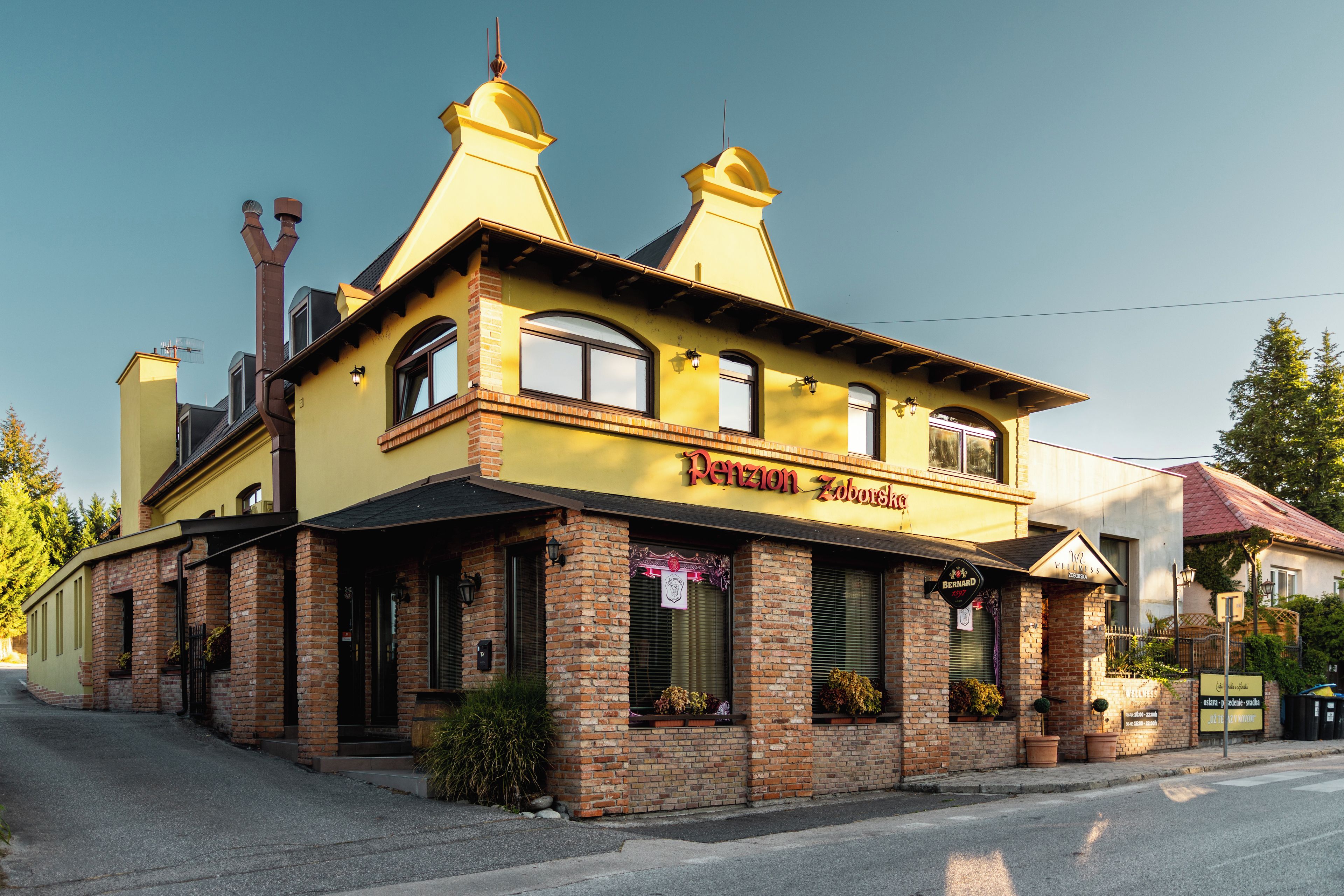 A yellow building with a sign that reads 'Pension Zoborská'.