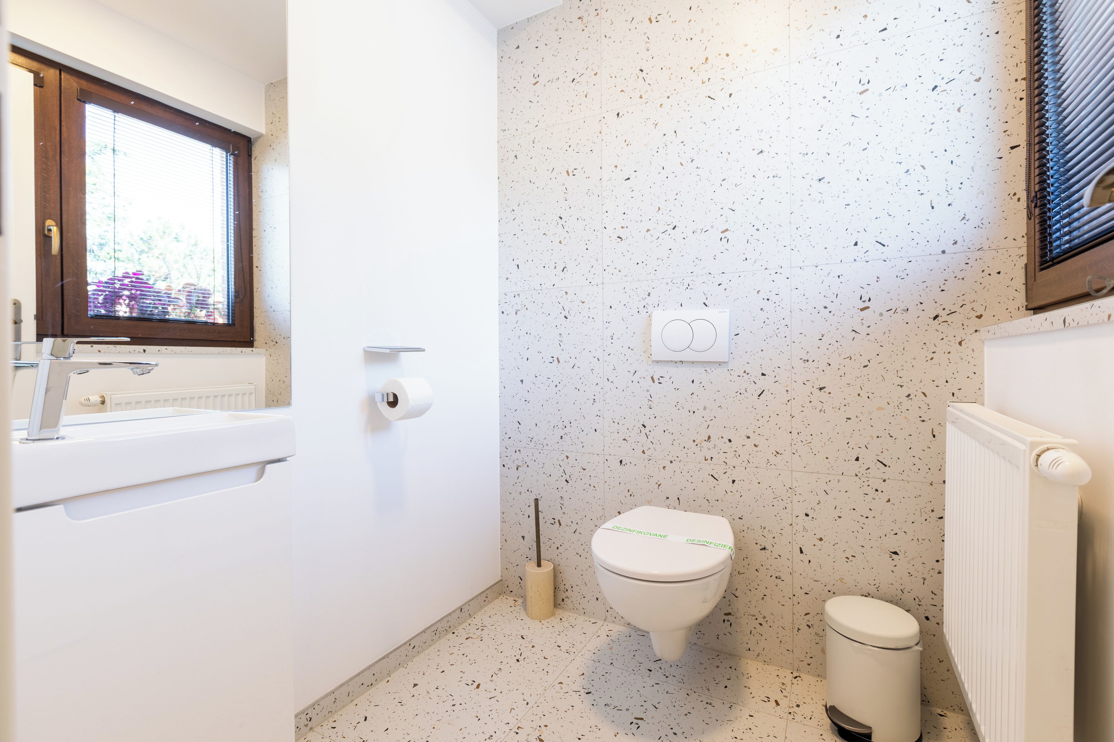 Un baño con inodoro, bidé, lavamanos y ventana.