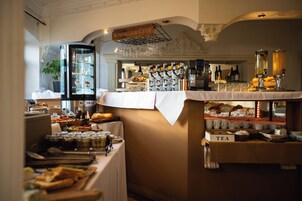 Montaje de bufé con diversos alimentos, una estación de té y una selección de vinos.