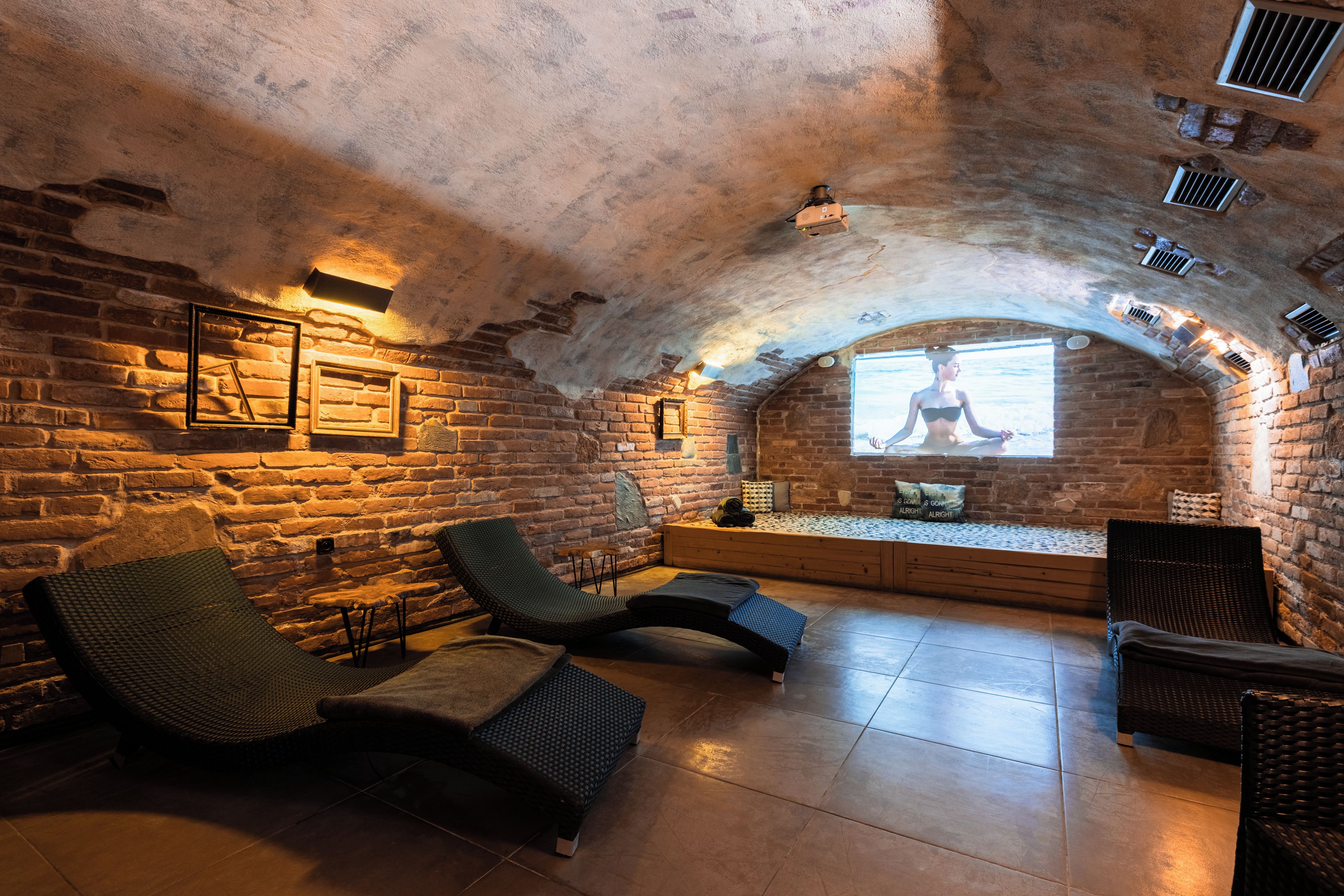 A cozy room with brick walls, a low ceiling, and a built-in bench with a view.