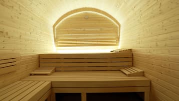 A sauna with wooden benches and a sloped ceiling.