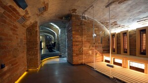 A stone-walled corridor with benches and a tiled floor. - Penzión & Wellness Zoborská (Nitra)