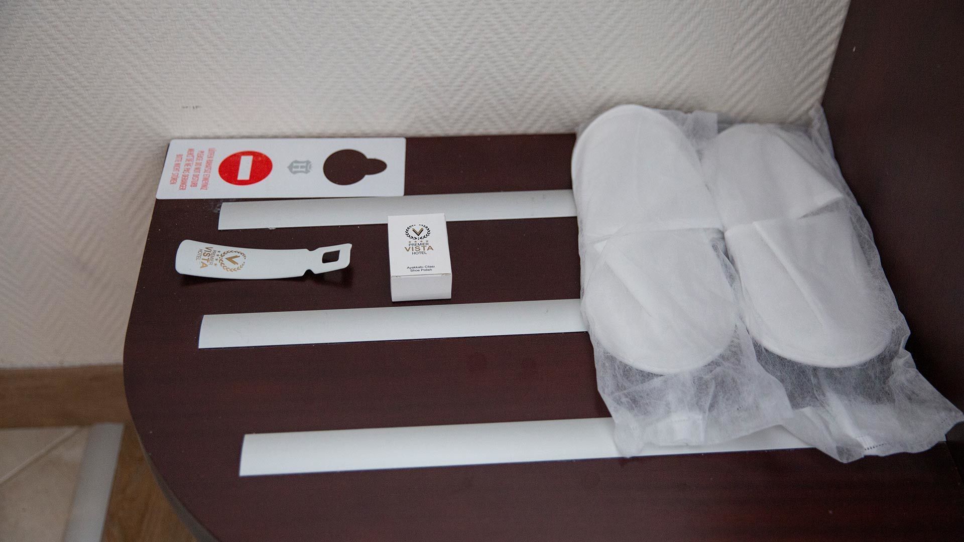 A set of white plastic items, including a tag, on a brown surface.