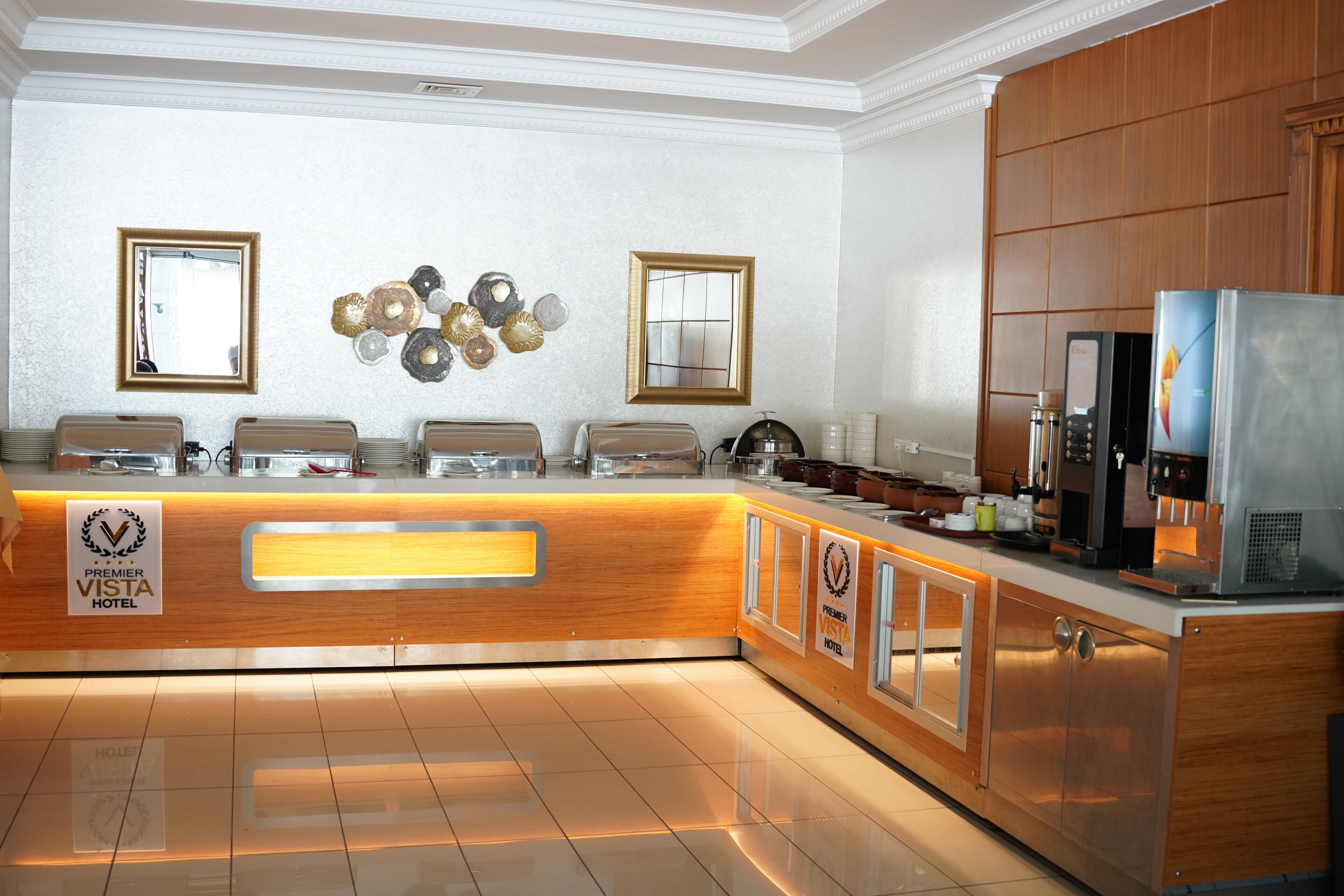 A hotel kitchen with a wooden counter, buffet setup, and stainless steel appliances.