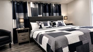 A bedroom with a bed, nightstands, a chair, and curtains.