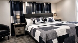 A bedroom with a bed, nightstands, a chair, and curtains.