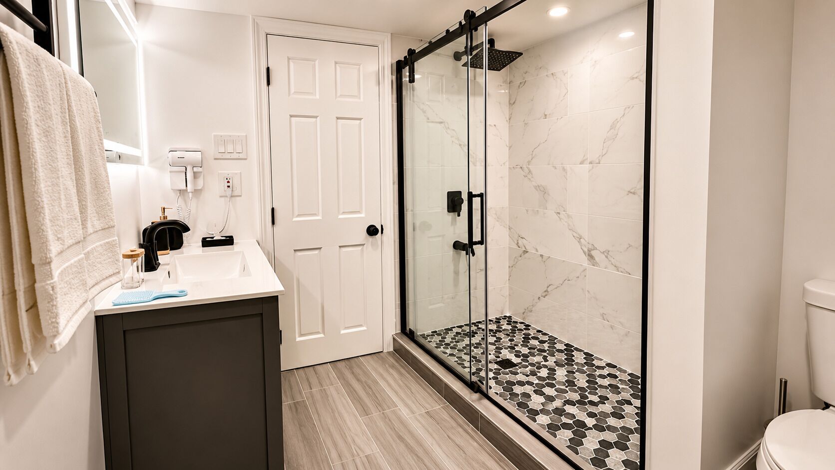 A bathroom with a shower, a sink, and a toilet.