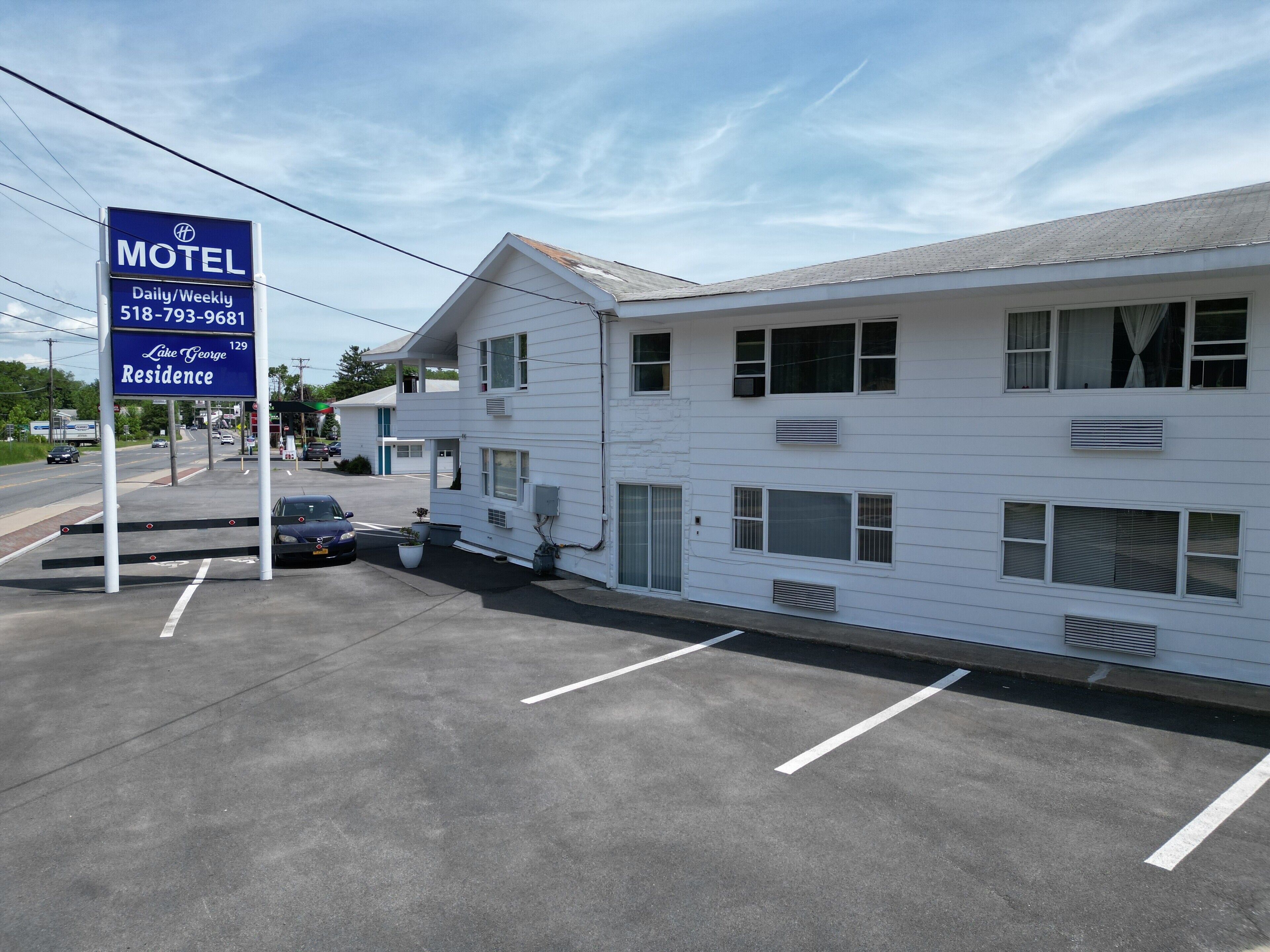 Un motel con un cartel que indica disponibilidad diaria y semanal, y un número de contacto.