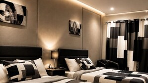 A hotel room with two beds, a nightstand, a lamp, and a wall-mounted artwork. - Lake George Residence LLC (South Glens Falls)