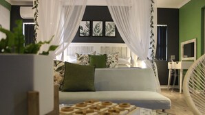 Une chambre moderne avec un lit, un canapé, une petite table et une chaise.