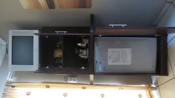 Una habitación con una televisión de pantalla plana grande, un mueble de madera y una mesita pequeña.