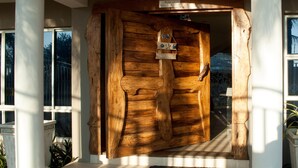 Une porte en bois avec une pancarte « Bienvenue », une autre indiquant « L’établissement se réserve le droit d’admission » et une plaque portant l’inscription « Chambre attribuée par la direction ».